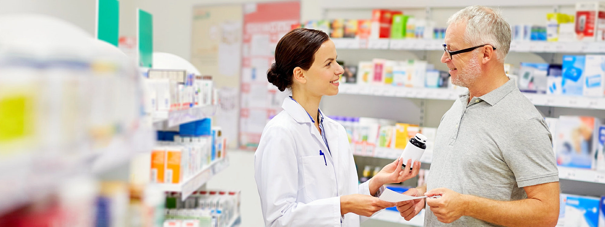 pharmacist giving customer meds with prescription